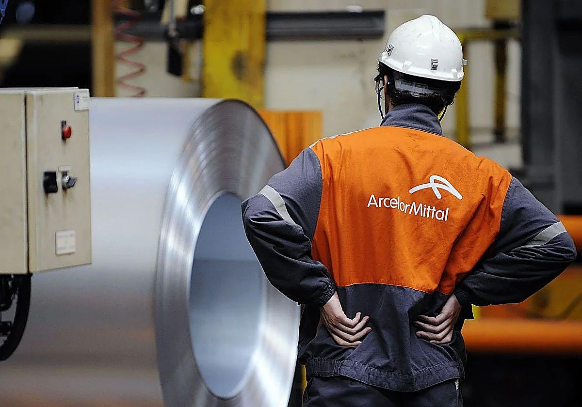 Trabajador de ArcelorMittal junto a una bobina de acero