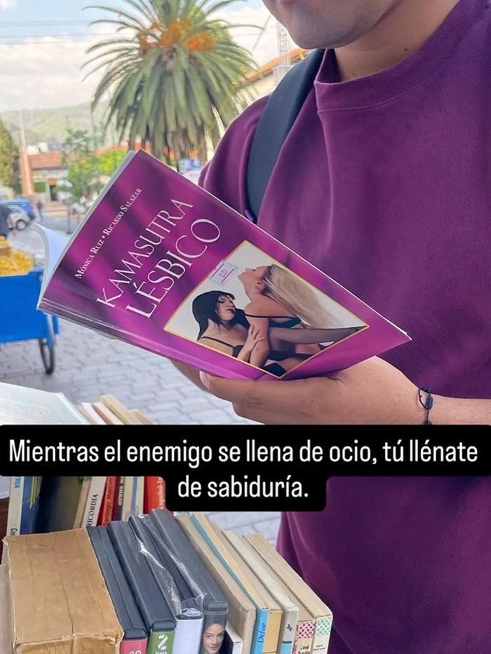 Hombre en un puesto de libros con un ejemplar de Kamasutra lésbico